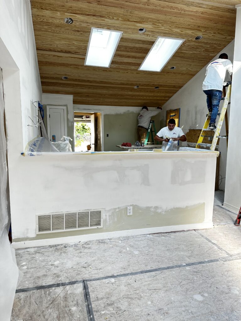 Mister Painter Group crew prepping kitchen walls and the half-wall peninsula for paint
